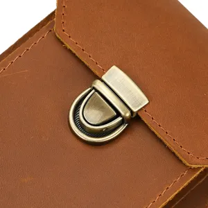 Close-up detail of vintage brown crazy horse leather phone waist bag with metallic clasp.