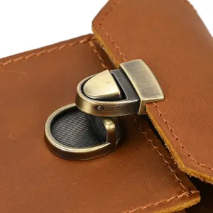Close-up of vintage brown leather waist bag metal lock buckle, detailed hardware craft.