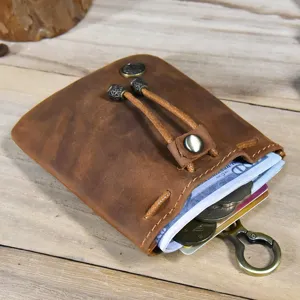 Retro handmade genuine leather coin purse with keychain and drawstring for women daily use.