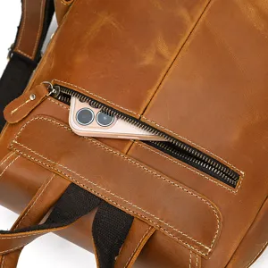 Detail shot of vintage crazy horse leather backpack zipper pocket with phone storage.