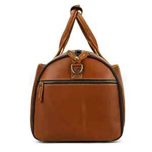 Detailed view of brown leather travel duffel bag, showing robust stitching and metal zippers.