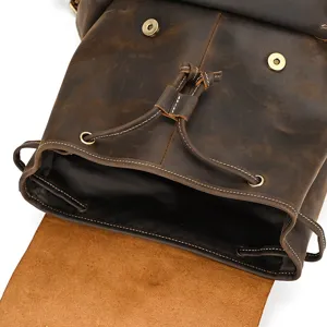 Close-up view of vintage brown leather backpack showing drawstring and durable metal hardware.