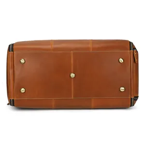 Leather travel duffel bag bottom detail view featuring durable metal protective feet.
