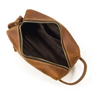 Close-up of brown genuine leather toiletry bag, interior view with zipper pocket and handle.