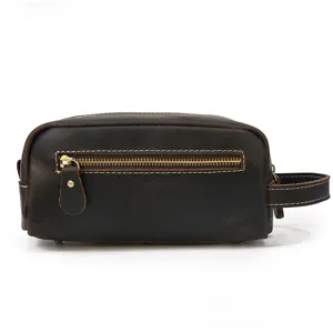 Genuine leather toiletry bag detail showing fine texture, durable metal zipper and side handle.