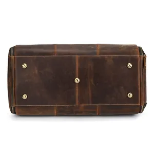 Genuine leather travel bag bottom detail, vintage brown duffel bag with durable metal feet.