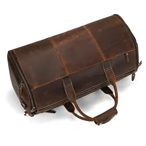 Close-up of vintage brown leather duffel bag showing fine stitching and durable zipper detail.