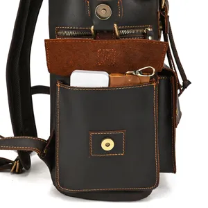 Close-up detail of the vintage leather backpack with metal zippers and multi-pocket design.