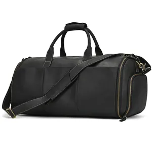 Black leather travel duffel bag detail showcasing hardware zippers and shoulder strap.