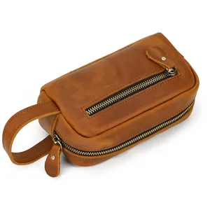 Close-up detail view of genuine leather toiletry bag with zipper and hand strap design.