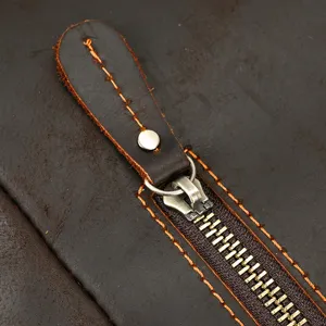 Vintage crazy horse leather backpack zipper detail close-up, durable travel bag design.