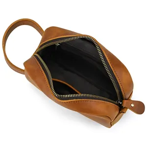 Detailed view of brown genuine leather toiletry bag interior, showcasing durable zipper and lining.