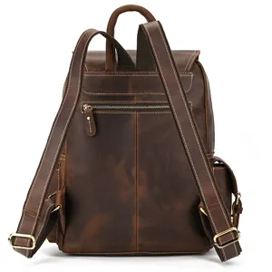 Close-up detail of the vintage brown leather backpack showing the back straps and zipper pocket.