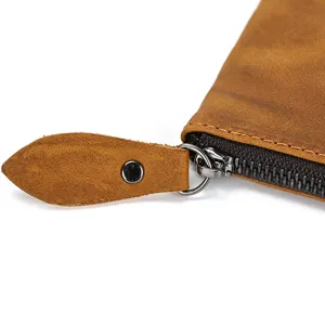 Primer plano detallado que muestra la cremallera y la textura de la cartera de cuero.