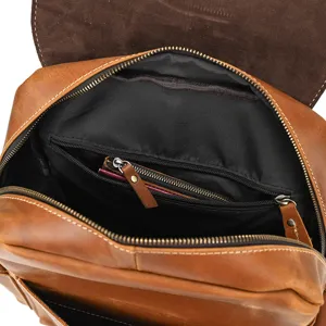 Detail view of vintage crazy horse leather backpack interior, showing pockets and zippers.