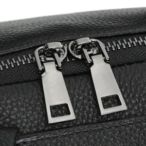 Close up detail shot of premium leather backpack metal zippers and high quality texture.