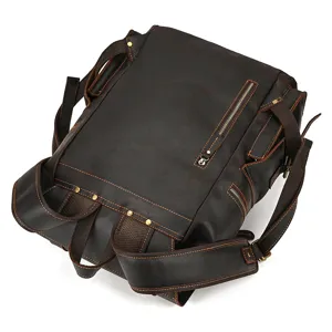Detail view of vintage brown leather backpack with multiple pockets and sturdy metal zippers.