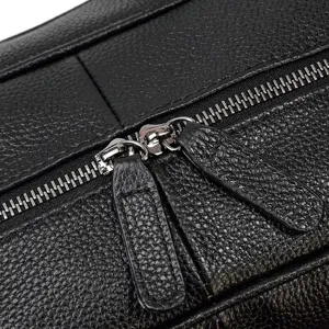 Close-up detail shot showing premium black cowhide leather texture, metal zippers, and pull tabs.