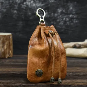 Detail view of vintage vegetable-tanned leather coin pouch with metal clasp and drawstring closure.