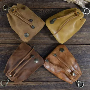 Close-up detail of retro handmade leather coin pouch with metal hook and drawstring.