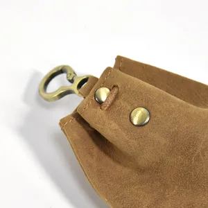 Close-up view of vintage brown leather coin purse detail, metal clasp and snap button.