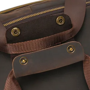 Gros plan sur le sac de voyage en cuir crazy horse vintage montrant des boutons et sangles.