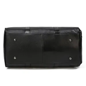 Black genuine leather travel duffel bag bottom detail showing metal feet and cowhide texture.