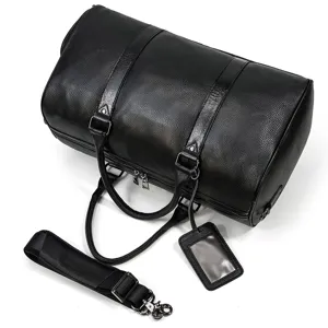 Close-up detail of black leather travel duffel bag with durable shoulder strap and luggage tag.