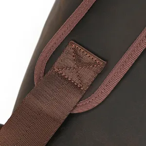 Gros plan détaillé sur la sangle en cuir marron résistante avec coutures croisées.