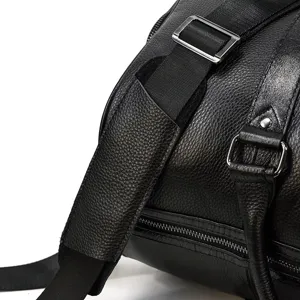 Close-up detail view of men's genuine leather travel duffel bag texture and hardware.