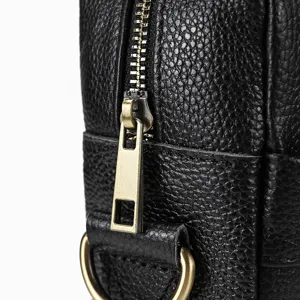 Close-up of men's leather bag zipper detail showing textured black cowhide and hardware.