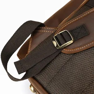 Vintage leather backpack detail shot with durable strap and metal buckle for men travel.