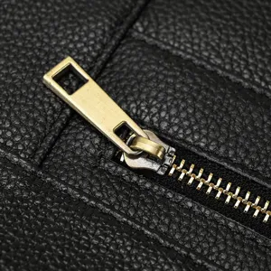 Premium leather briefcase zipper detail, durable metal hardware and fine texture close-up.