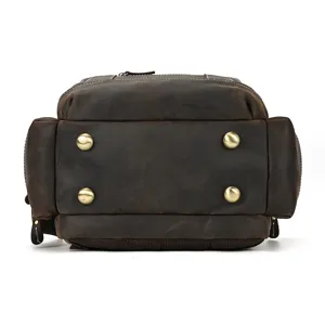 Detailed bottom view of men's vintage genuine leather backpack, showcasing durable brass feet.