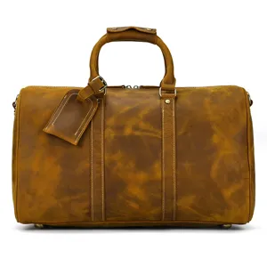 Détail de sac de voyage vintage en cuir véritable avec poignées solides et étiquette élégante.
