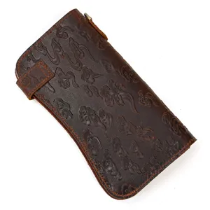 Vue rapprochée du portemonnaie long en cuir vintage avec des motifs gaufrés traditionnels.