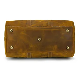 Vue détaillée du fond du sac de voyage en cuir vintage avec des clous de protection.