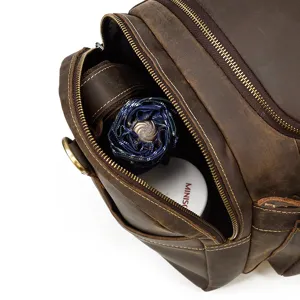 Dettaglio ravvicinato della borsa da viaggio in pelle con ampio scomparto interno.