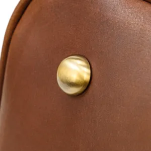 Close up detail of brown genuine leather bag with vintage metal rivet hardware accessory.