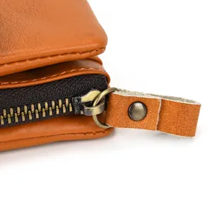 Close-up detail shot of vintage genuine leather wallet zipper and textured pull tab craftsmanship.