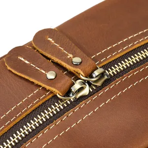 Close-up detail of vintage crazy horse genuine leather pouch featuring metal zipper and neat stitching.