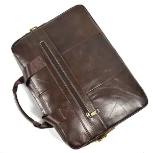 Closeup detail of brown leather business briefcase, showcasing durable metal zippers and handle.