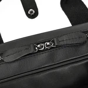 Leather briefcase detail view, black genuine leather with fine stitching and durable metal zippers.