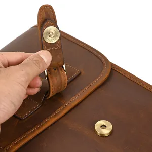 Vista de primer plano detallada de la hebilla magnética y textura del bolso de cuero vintage.