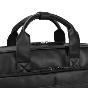 Close up detail view of black leather business briefcase handle and durable metal zipper.