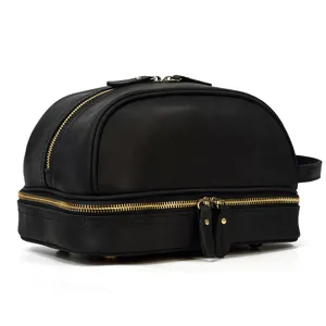 Close-up detail of black genuine leather double layer toiletry bag with smooth gold zippers.