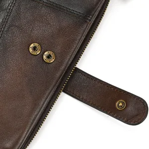 Close-up detail of retro distressed cowhide leather wallet with metal snap button and zipper.