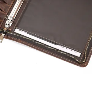 Detailed view of genuine leather A4 document folder interior with ring binder and pen slots.