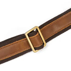 Close-up view of durable genuine leather and canvas shoulder strap detail with metal buckle.