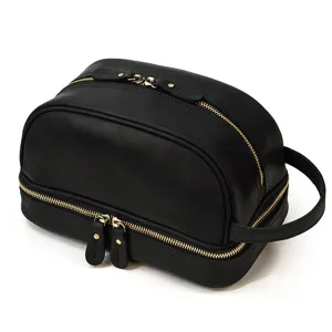 Black leather double zipper toiletry bag detail, metal zipper hardware and side handle.
